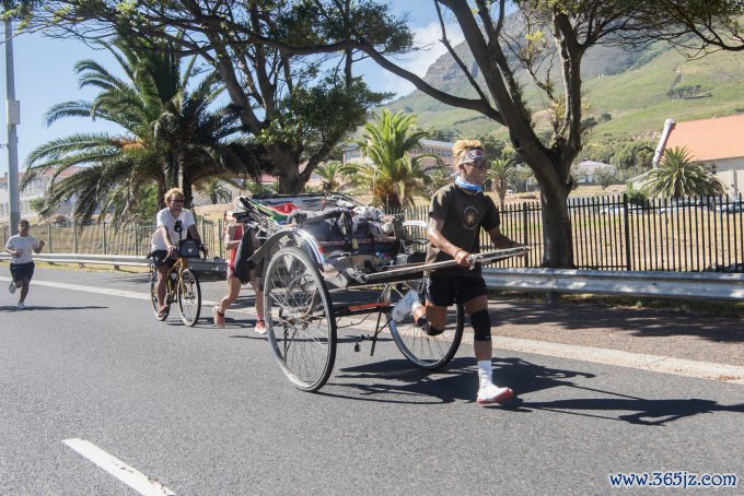 Yuji Suzuki kéo xe chạy bộ ở Cape Town， Nam Phi ngày 26/1. Ảnh: AFP